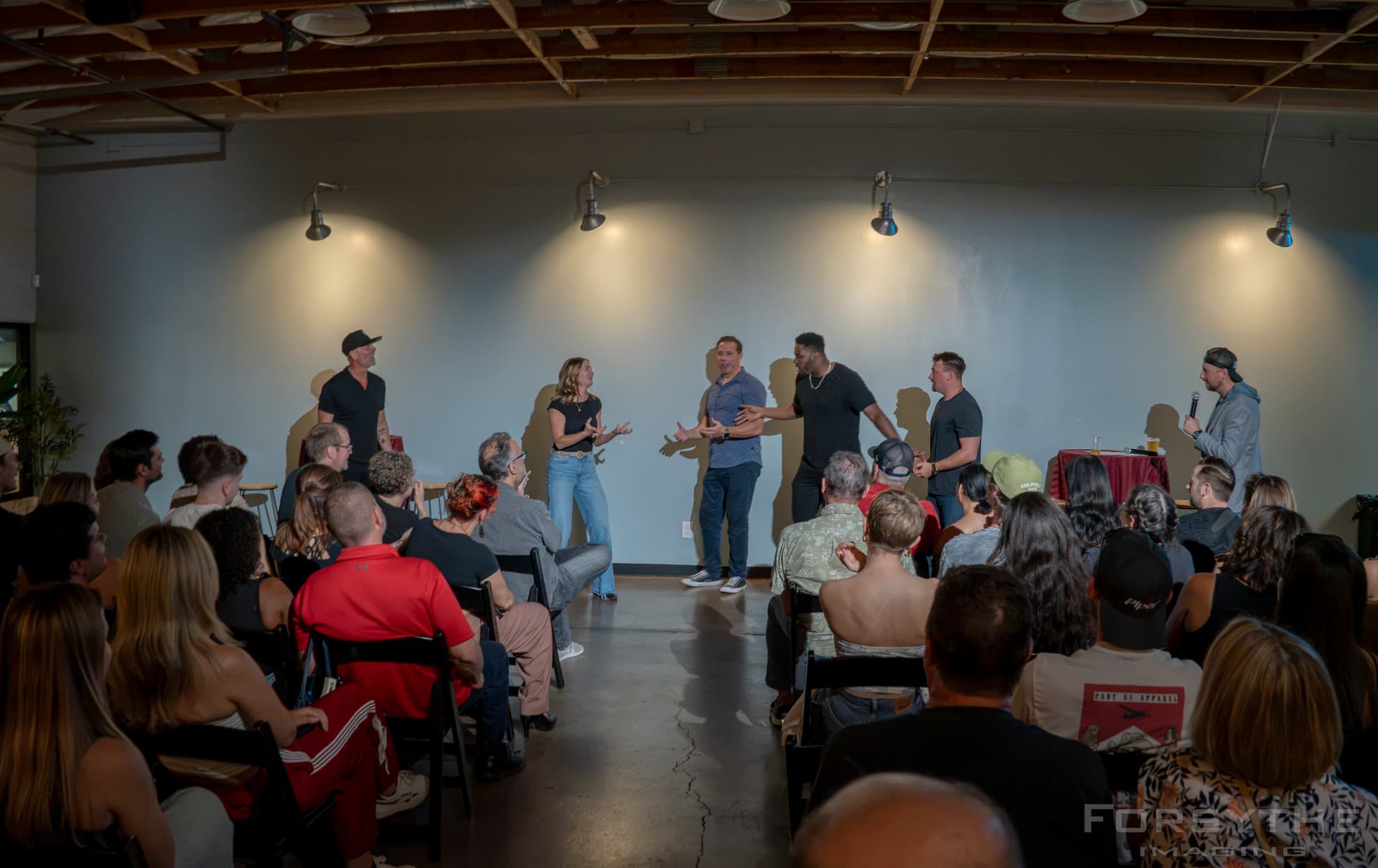 Improv troupe playing a scene in front of a packed room at Arizona After Dark